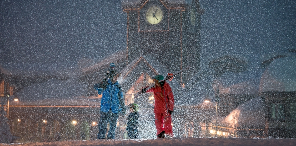 Family walking with their skis in the snow