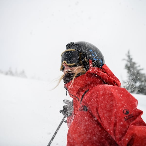A close up of a skier smiling in a red jacket at Revelstoke Mountain Resort