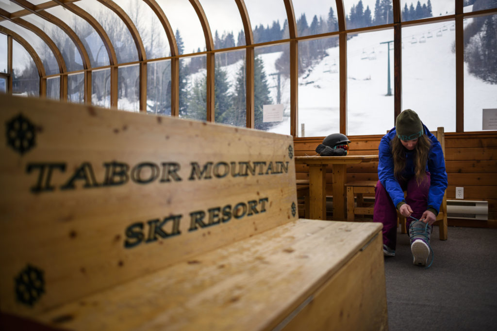A woman tying her snowboard boots