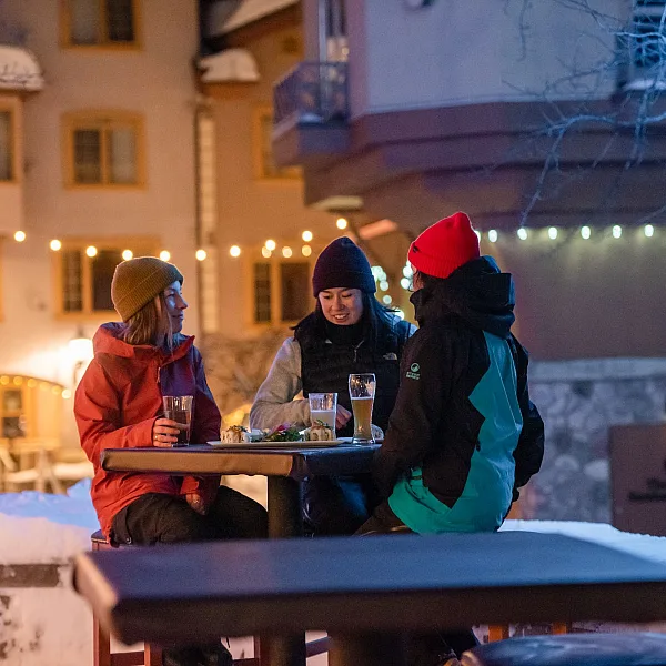 Tres mujeres compartiendo una cerveza afuera
