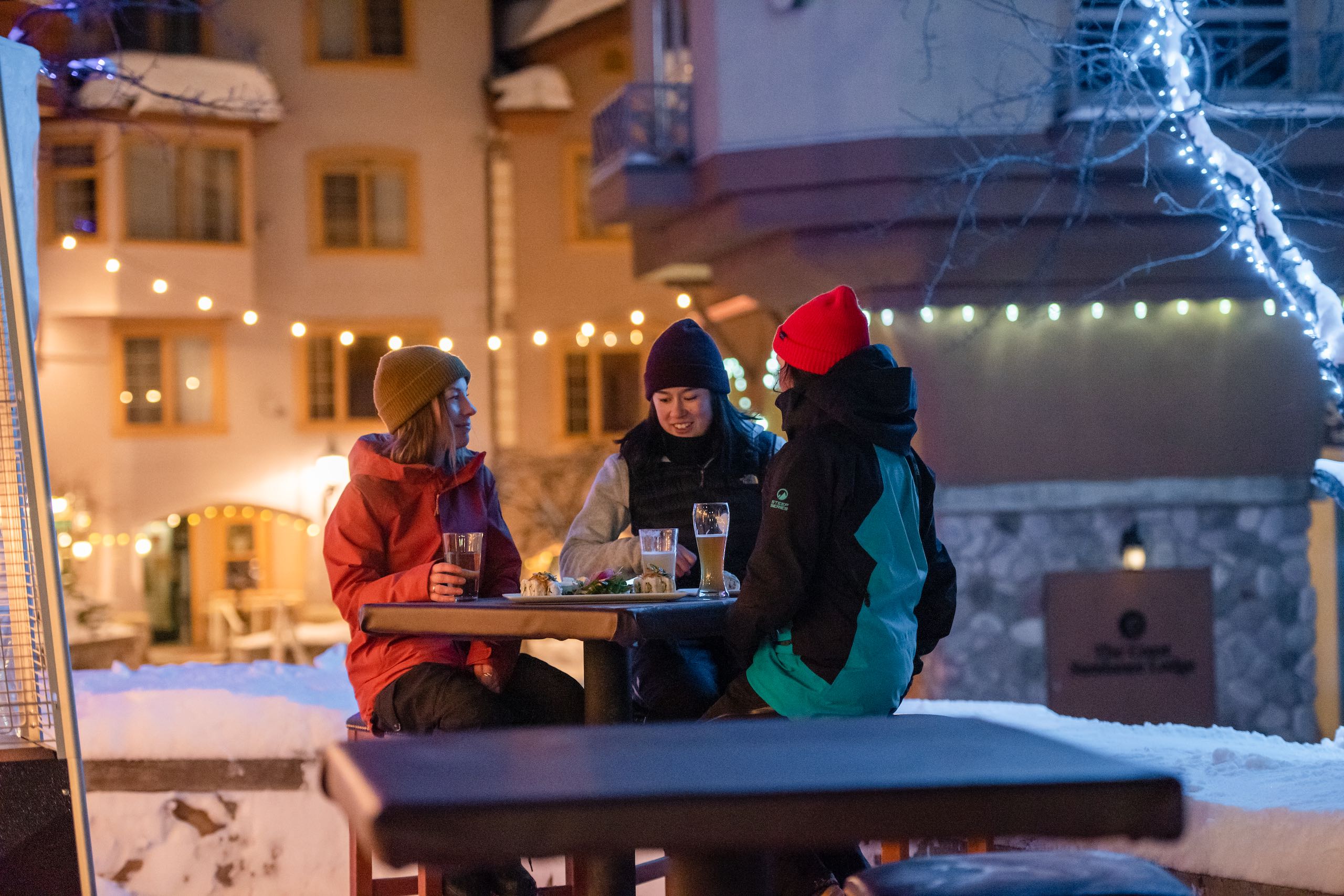 Three women sharing a beer outside