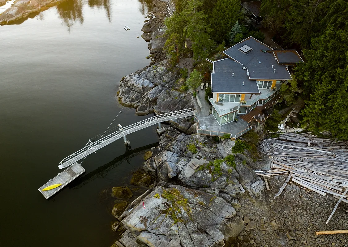 Luftaufnahme von Pointhouse Suites, einem Haus am Wasser mit einem großen Steg, der ins Wasser hinausragt.
