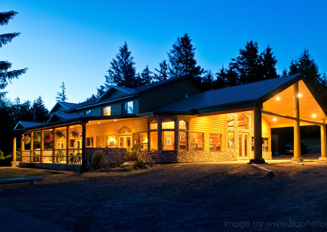 Outside of the Haida House at night. Lights are on illuminating the building.