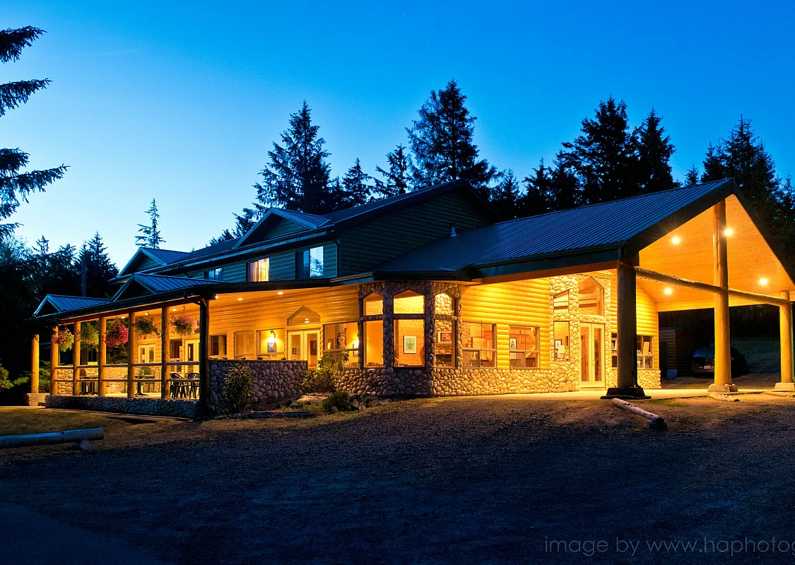 Outside of the Haida House at night. Lights are on illuminating the building.