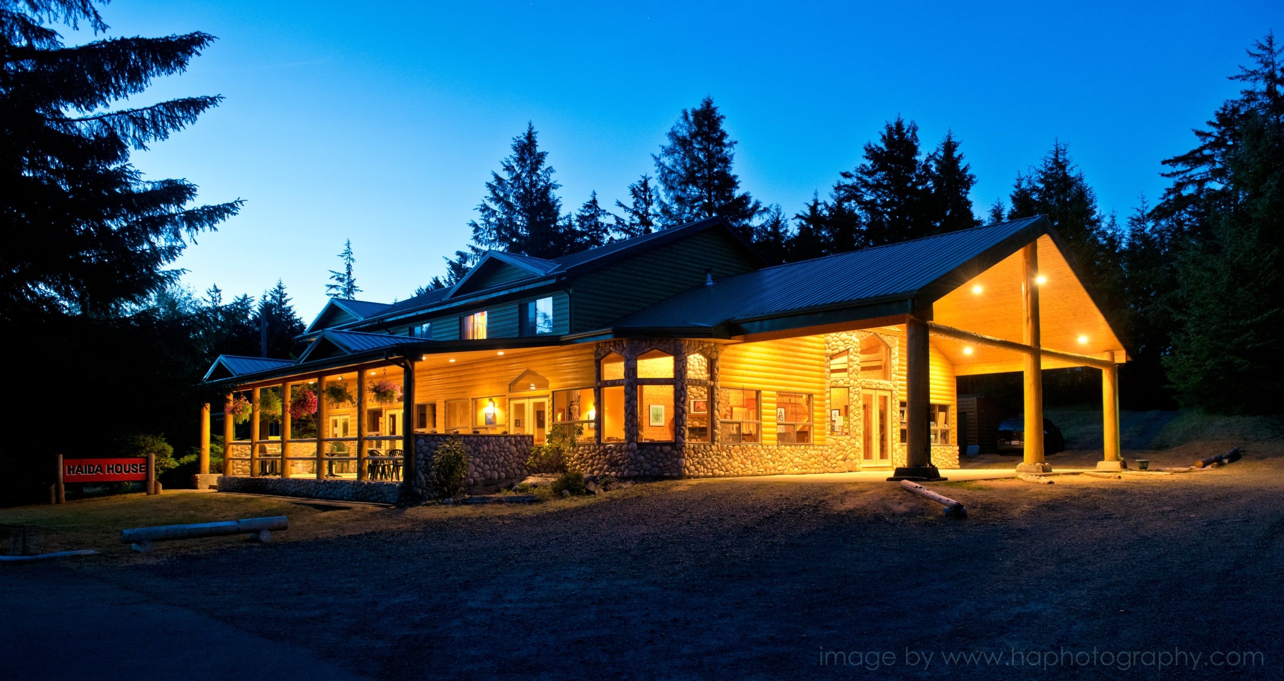 Outside of the Haida House at night. Lights are on illuminating the building.