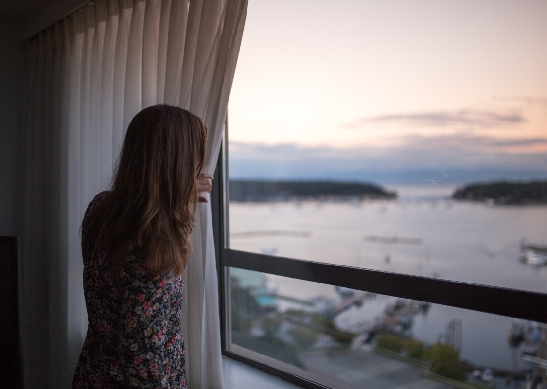 Eine Frau blickt aus ihrem Fenster vom Coast Bastion Hotel aus.