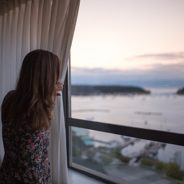 A women looks out her window from the Coast Bastion Hotel