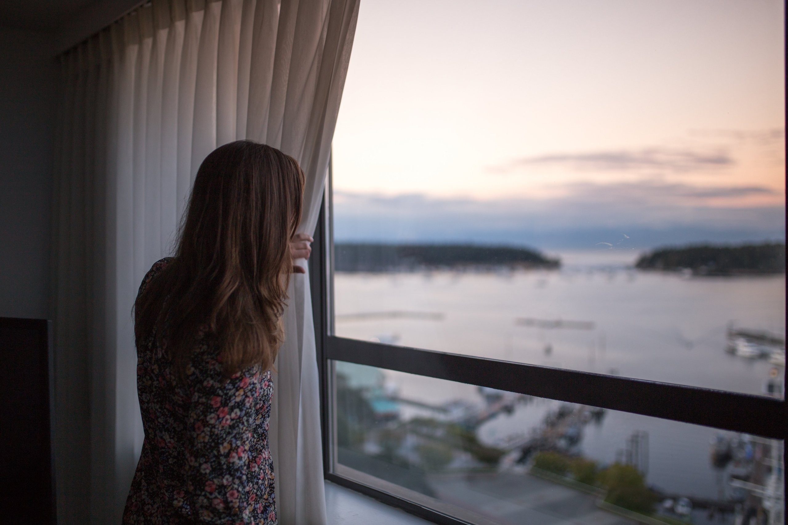 A women looks out her window from the Coast Bastion Hotel