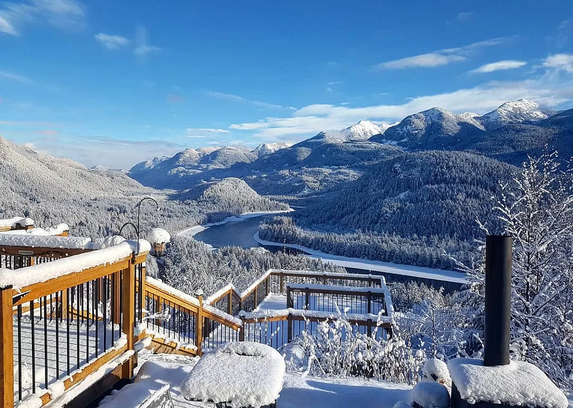 Eine verschneite Aussicht auf den Fraser River und die Berge von der American Creek Lodge.