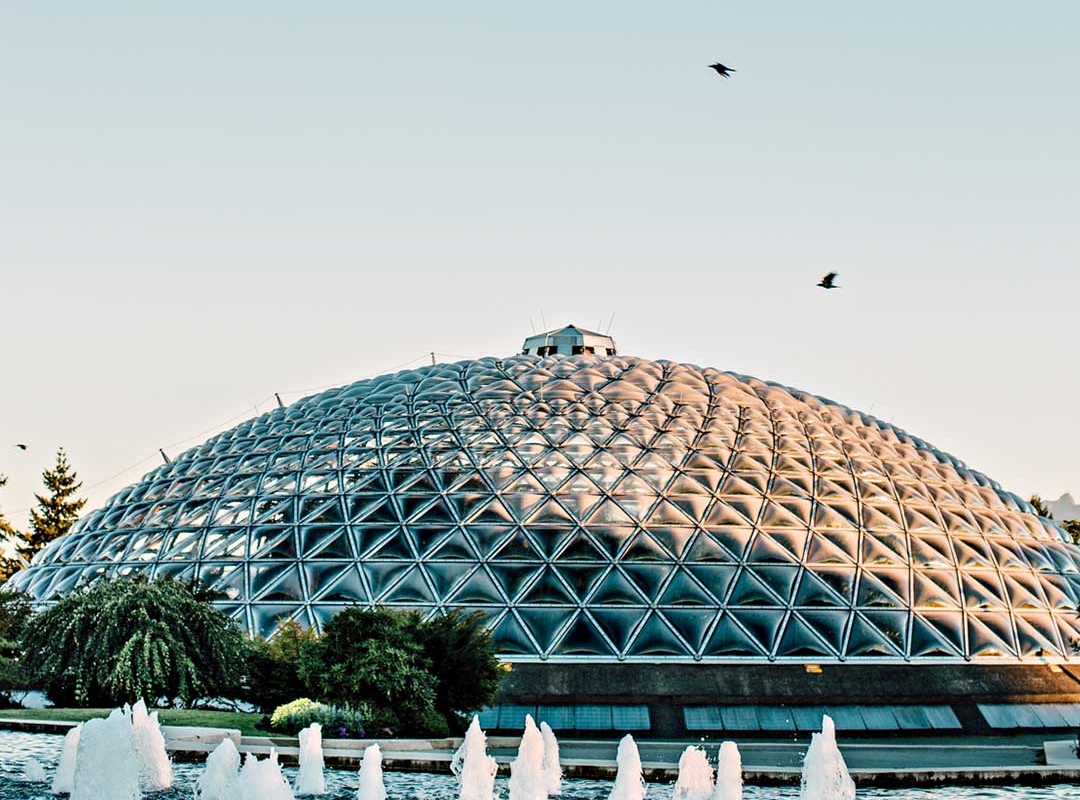 Ein Dutzend kleiner Springbrunnen fließt aus einem Becken vor der Glaskuppel des Bloedel Conservatory
