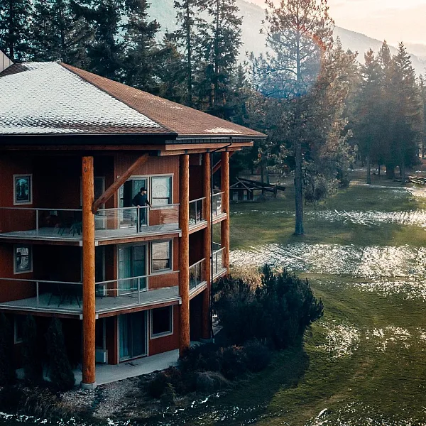 Ein Blick von außen auf die Quaaout Lodge & Spa im Talking Rock Golf Resort. Ein leichter Schneestaub liegt auf dem Dach und der Wiese.