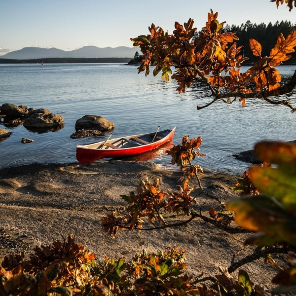 A red canoe sits on the beach on Gabriola Island