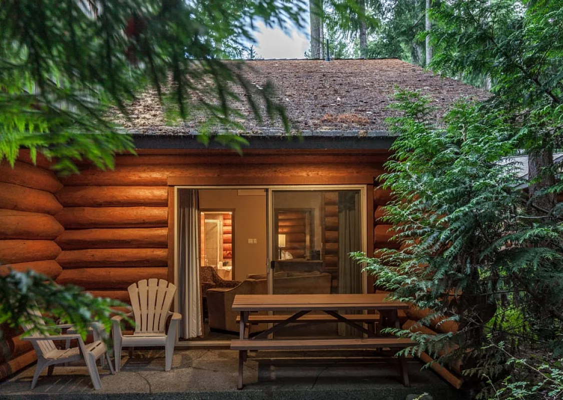 El exterior de una acogedora cabaña de madera en el bosque