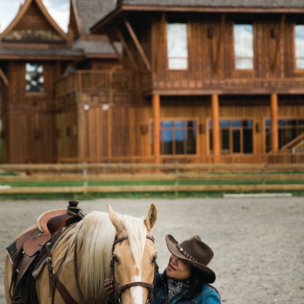 A women stands next to a horse outside of the Echo Valley Ranch & Spa.