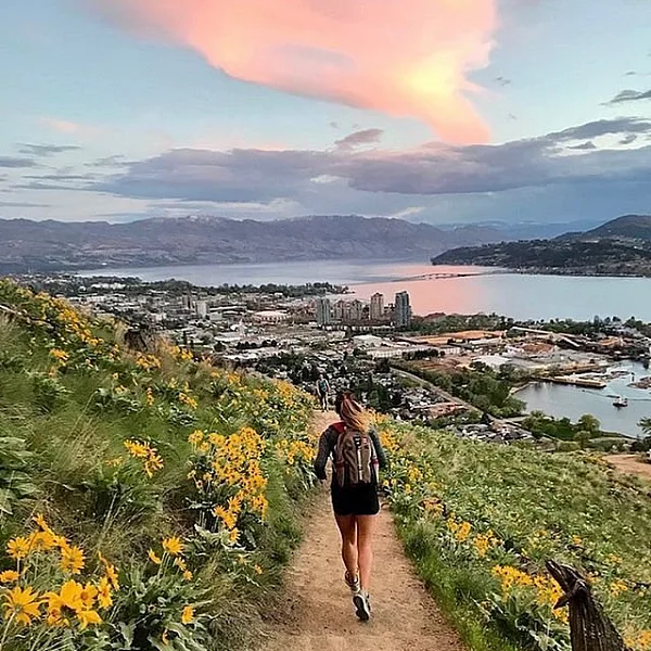 Jogger running along a dirt trail overlooking the lake