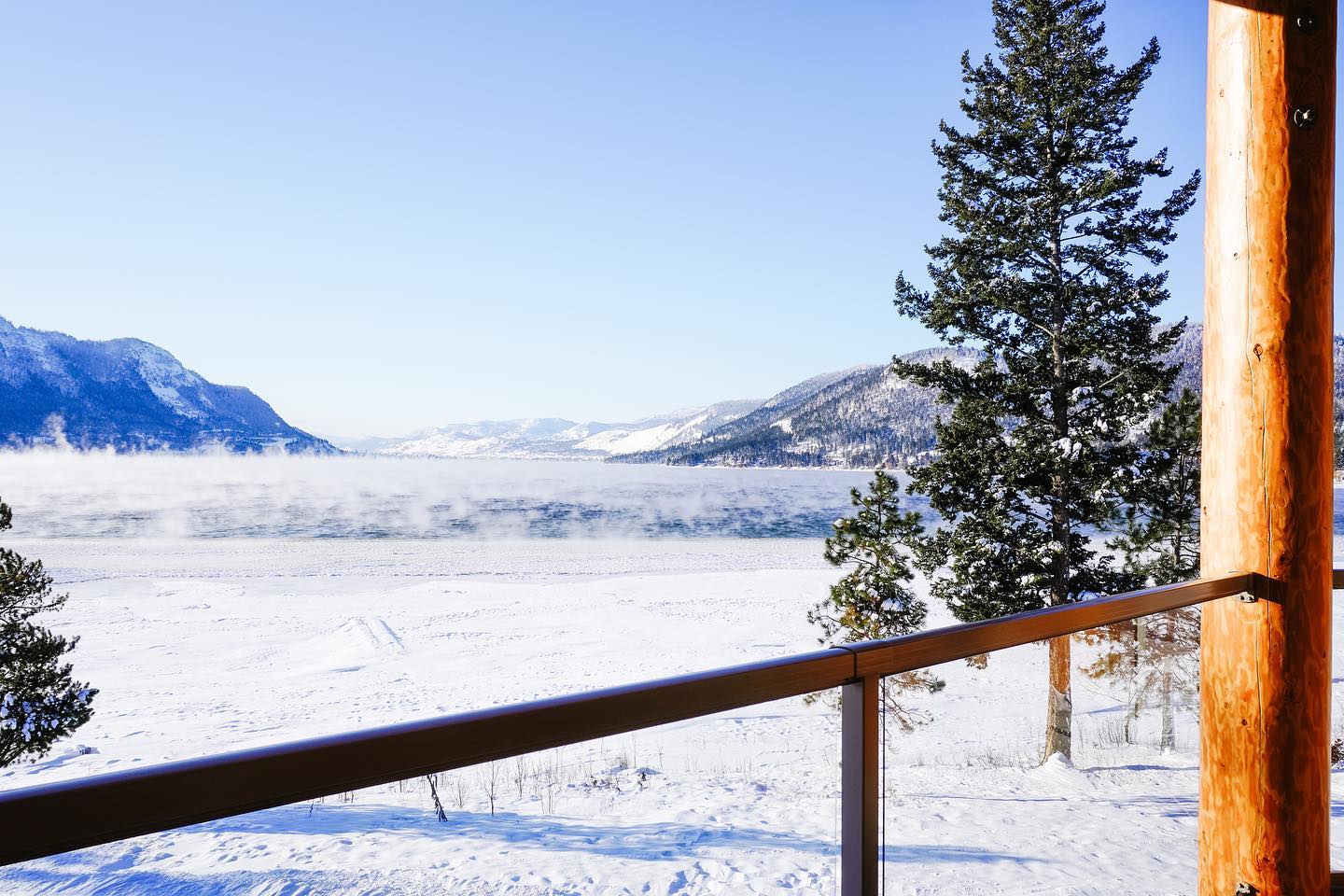 Snowy views from the patio at Quaaout Lodge looking out into a vast empty field with mountains in the distance.