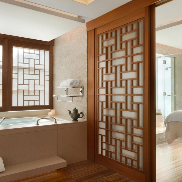 A spa bathroom with a slider door to a bedroom