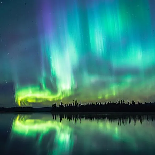 The Northern Lights in the sky over a lake on the Cariboo Chilcotin Coast