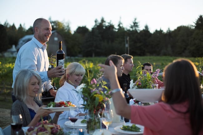 Al fresco dining with a large group at a long table in the summer at Vista D'oro Vineyard in Langley.