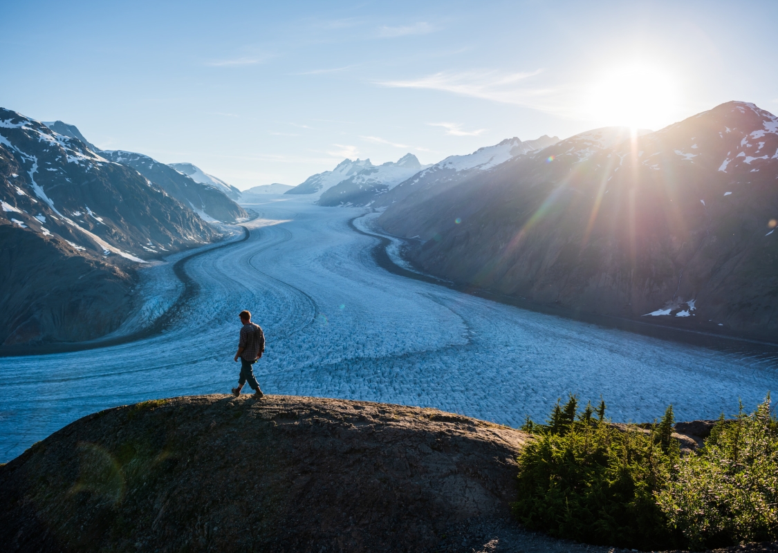 Man walking on a hill next to a river