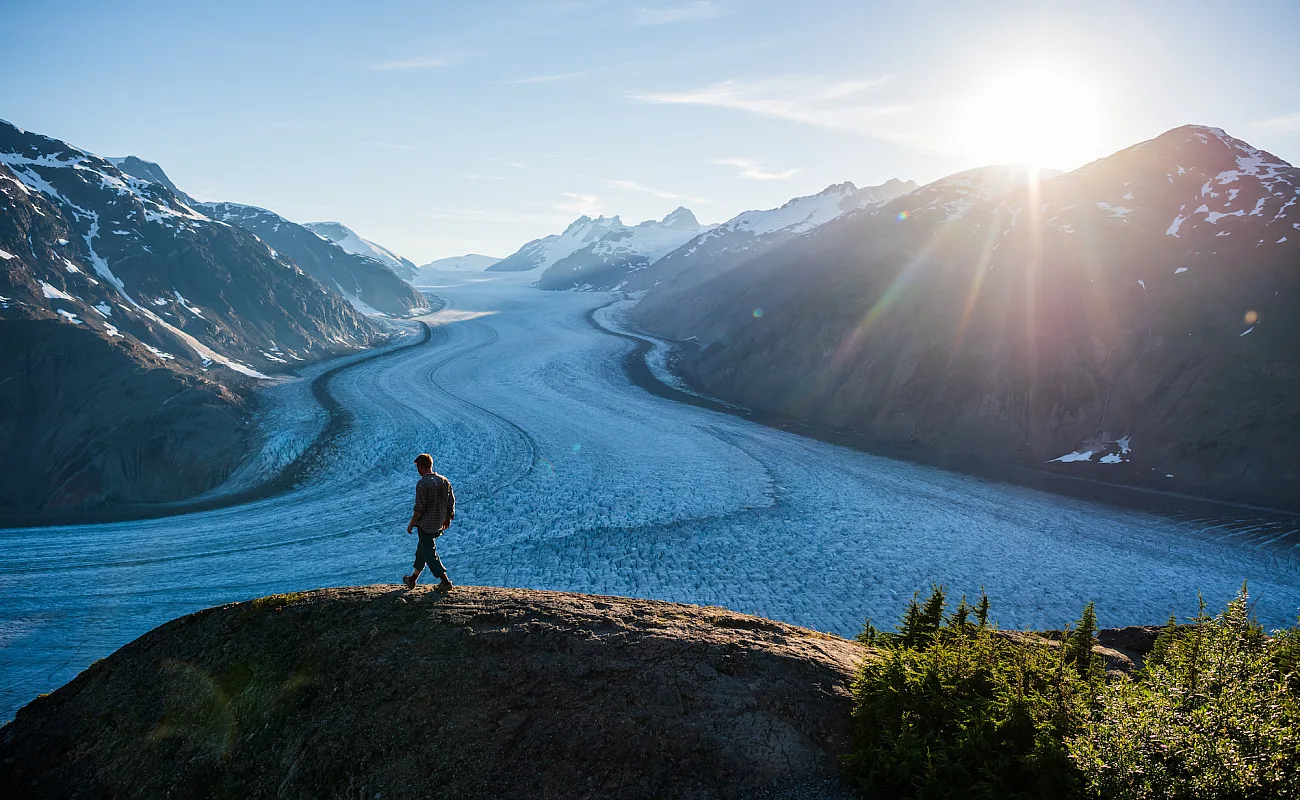 Man walking on a hill next to a river