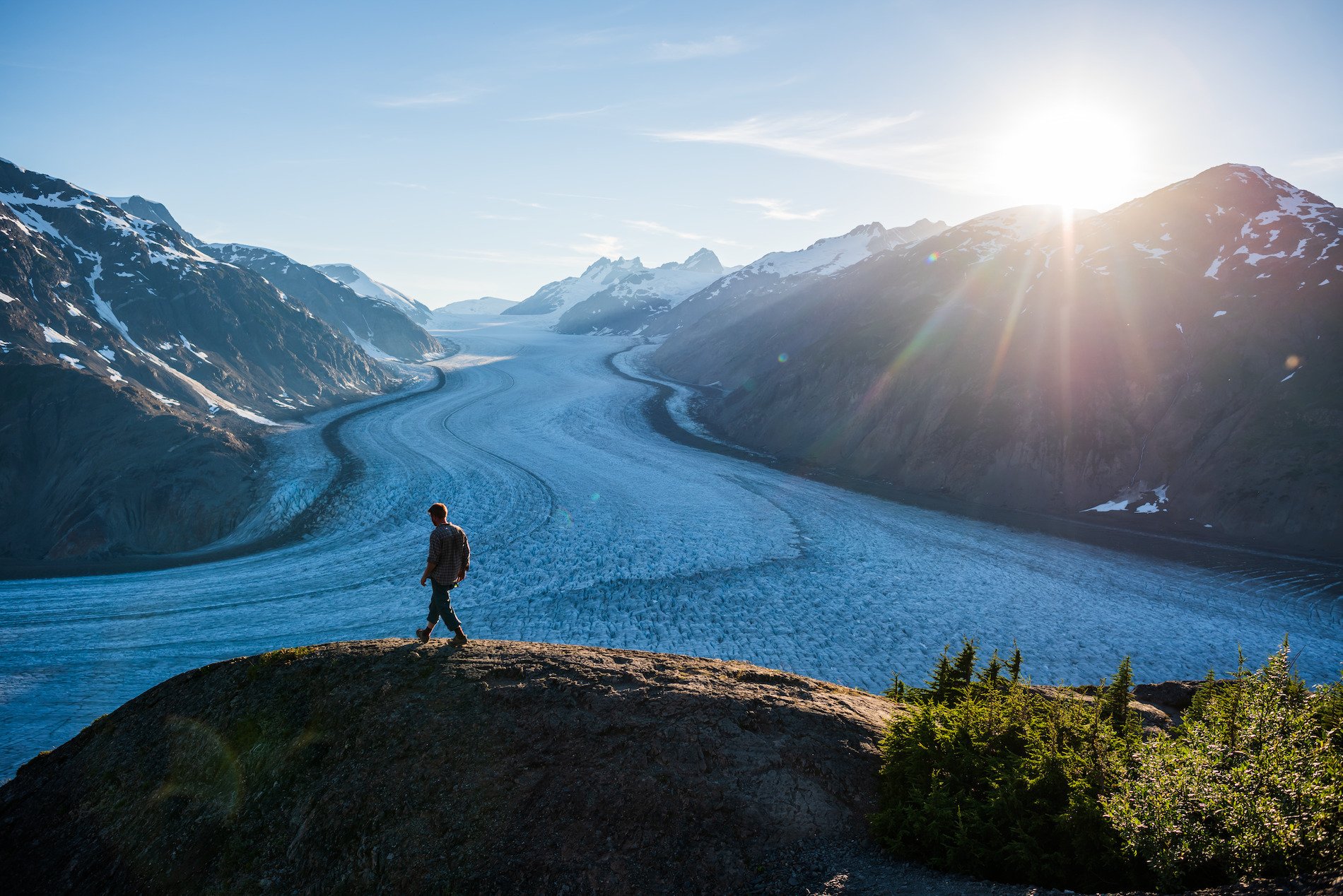 Man walking on a hill next to a river