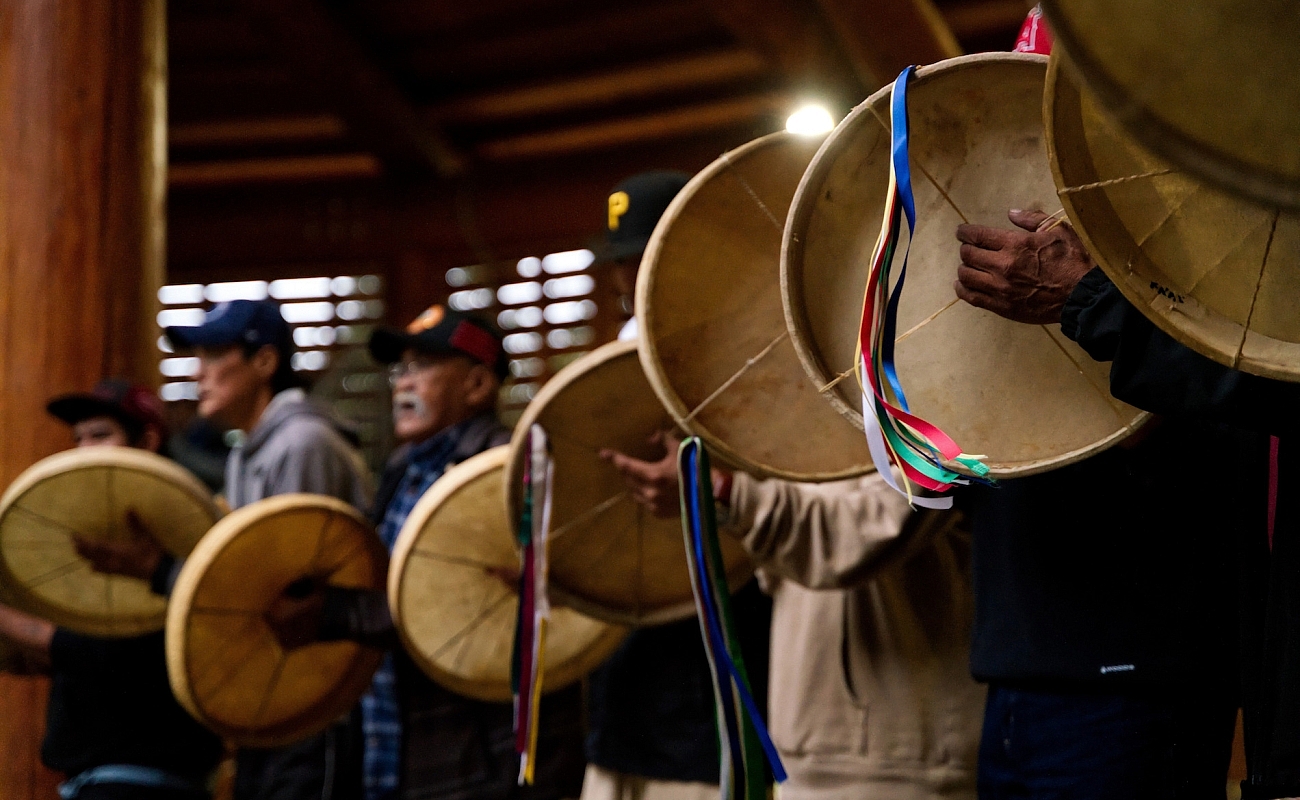 A group of Indigenous people drum at the Traditional Dene Drum Dance.