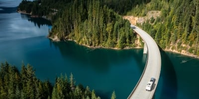 Aerial view of an RV crossing a bridge over a lake.