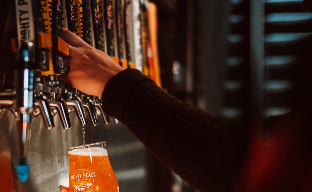A person pours a cool pint of beer at the taps of Mighty Peace Brewery in Fort St. John.