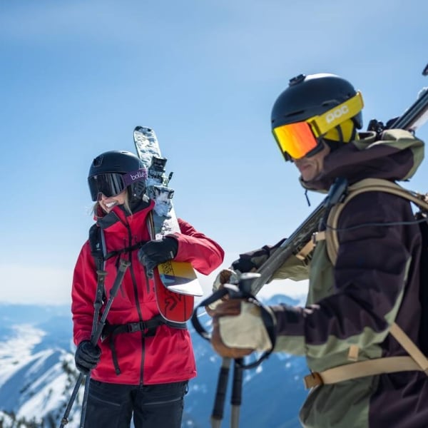 Two skiers on top of the mountain under bluebird conditions at Kicking Horse Mountain Resort near Golden.