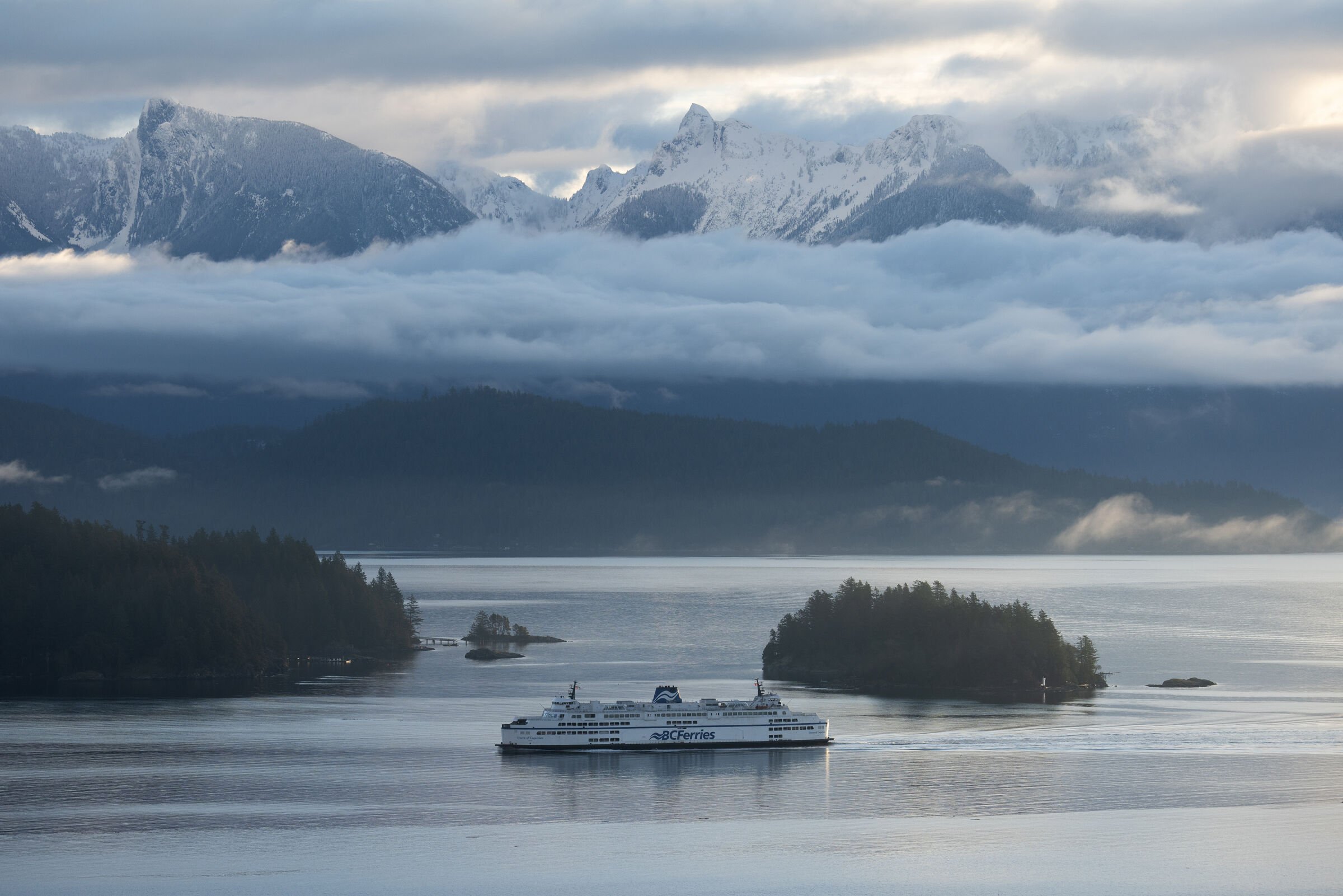 Ferry arriving to Langdale with snow capped North Shore mountains towering behind.