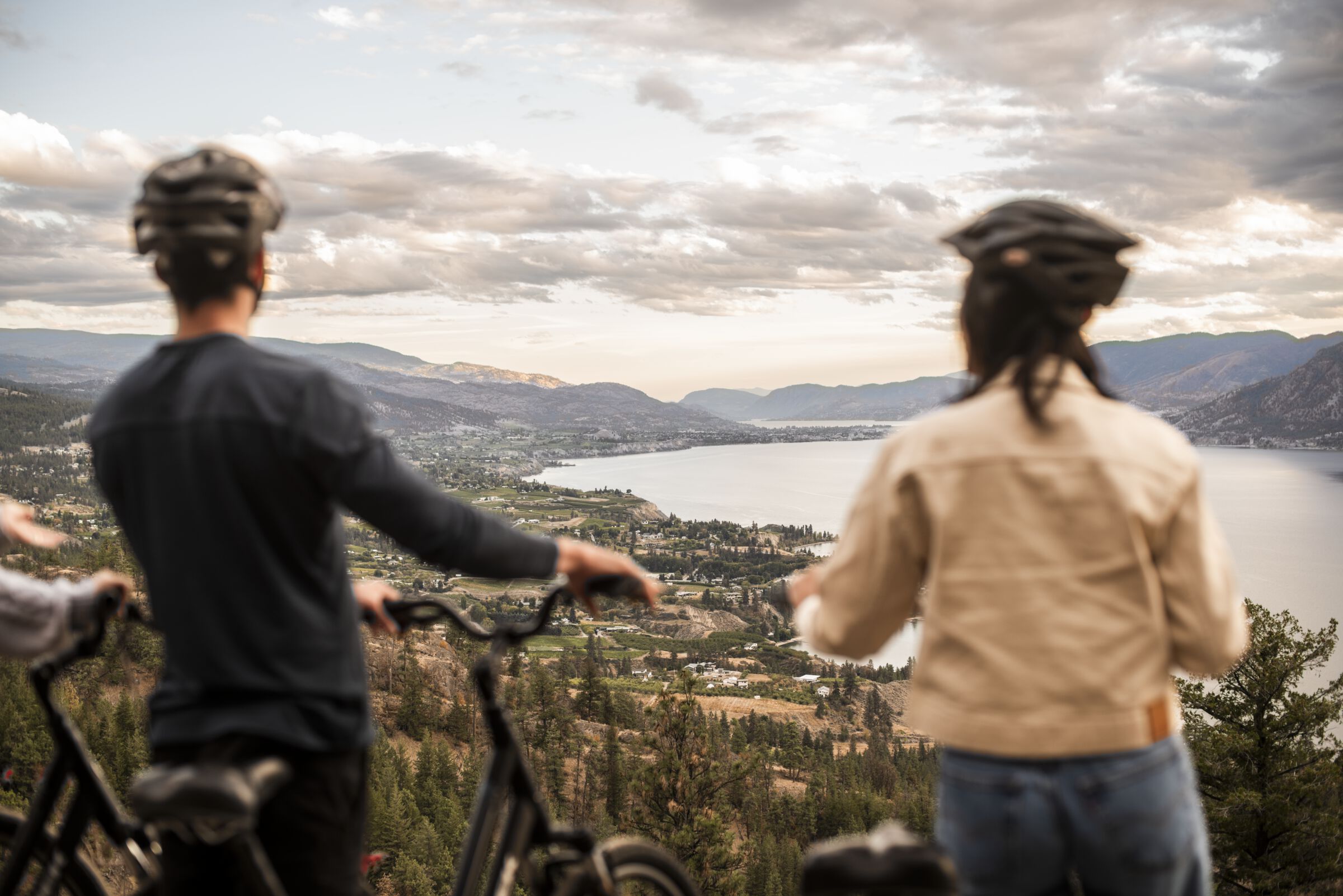 A couple enjoying the view of Naramata and Okanagan Lake during their bike ride along the Kettle Valley Rail Trail.