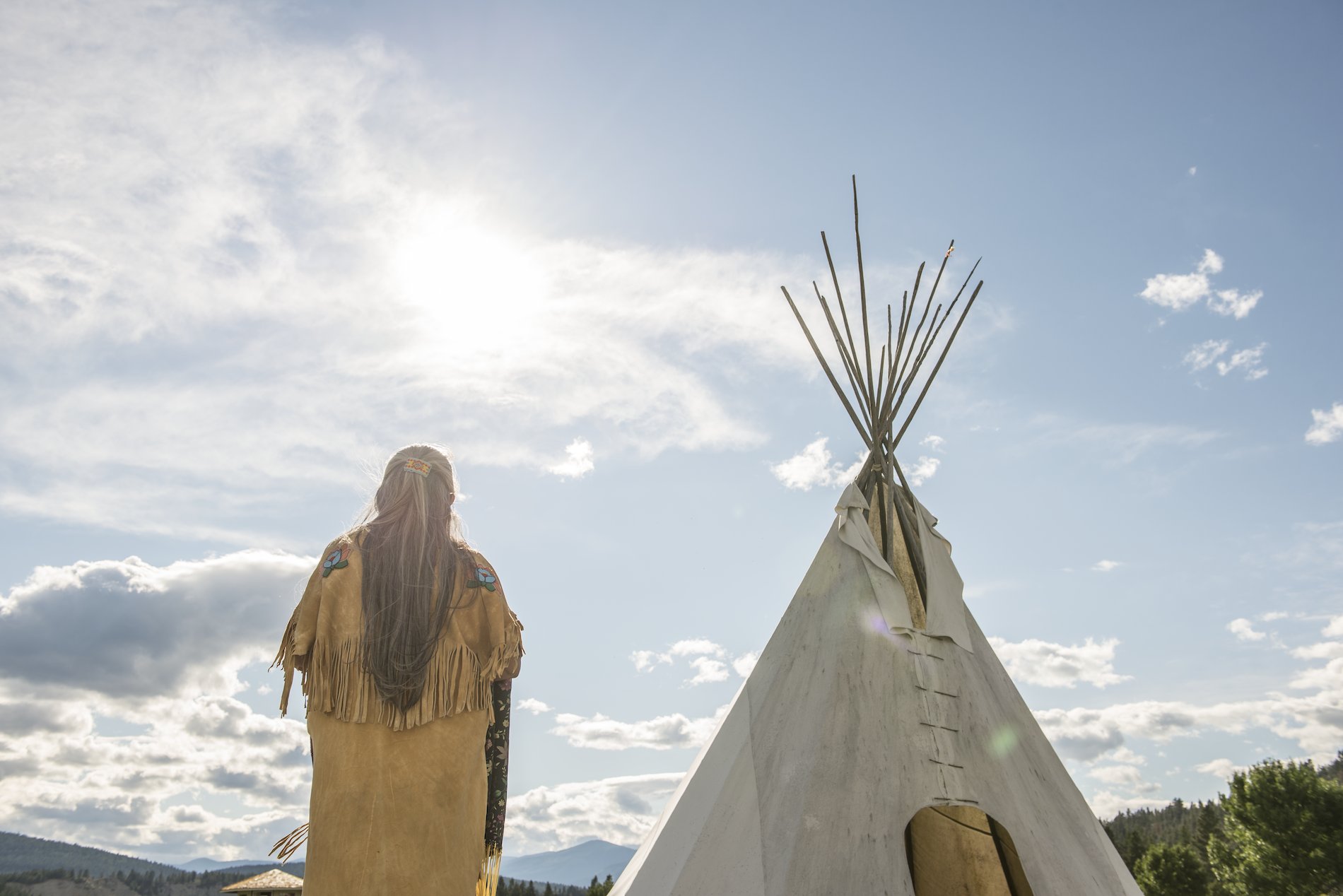 Ktunaxa elder in regalia next to a teepee at St Eugene Golf Resort.