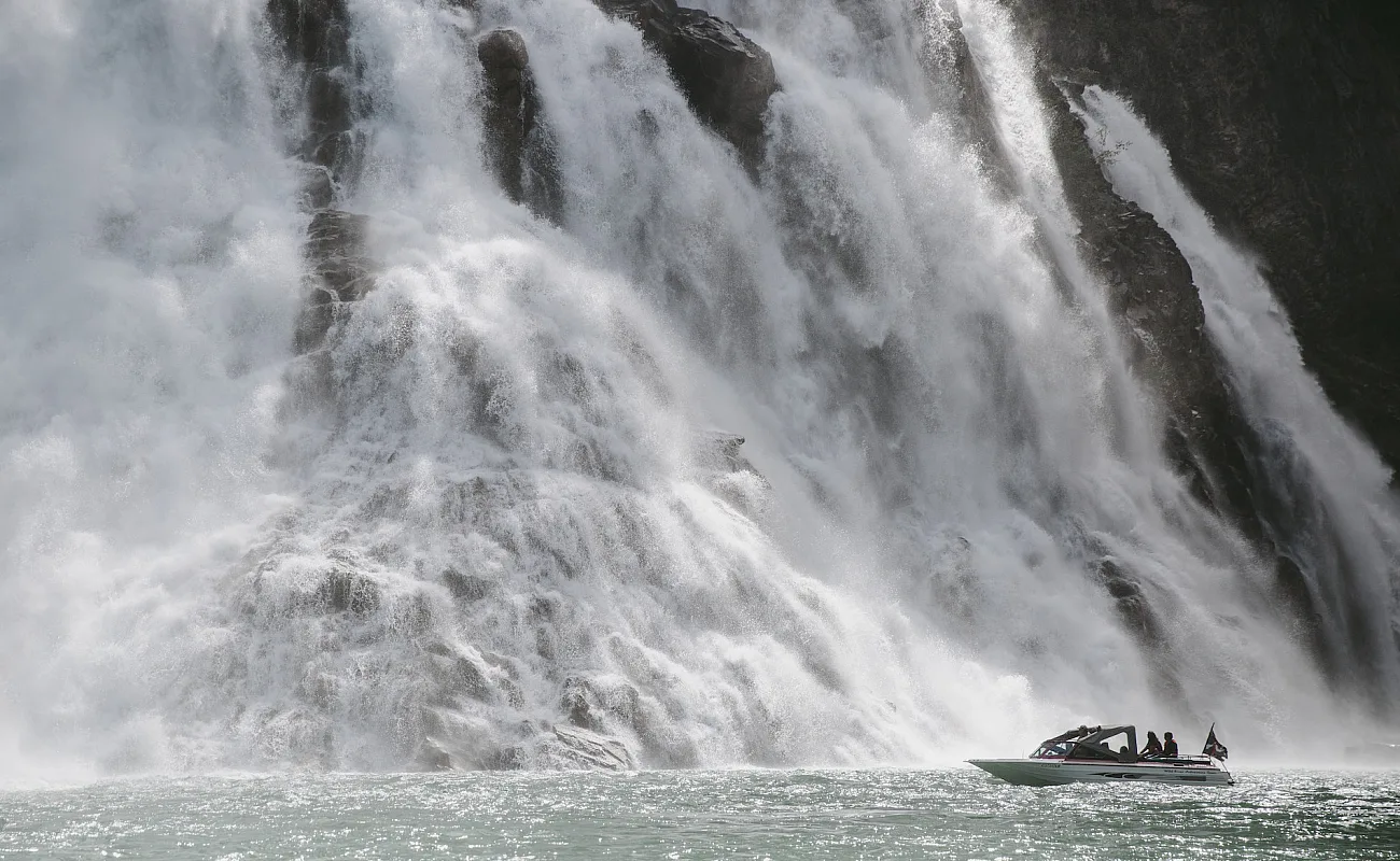 A boat next to a large waterfall