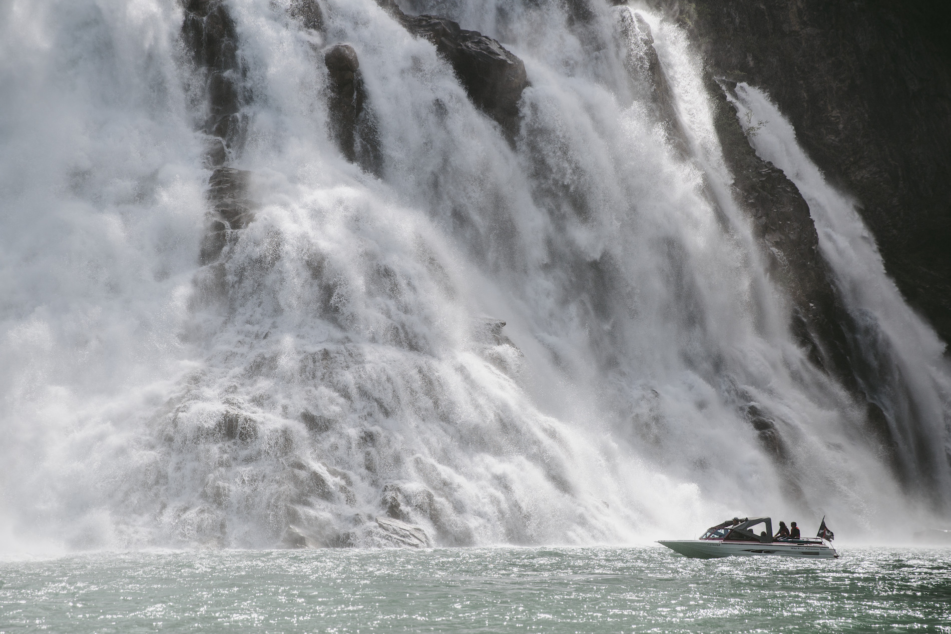 A boat next to a large waterfall