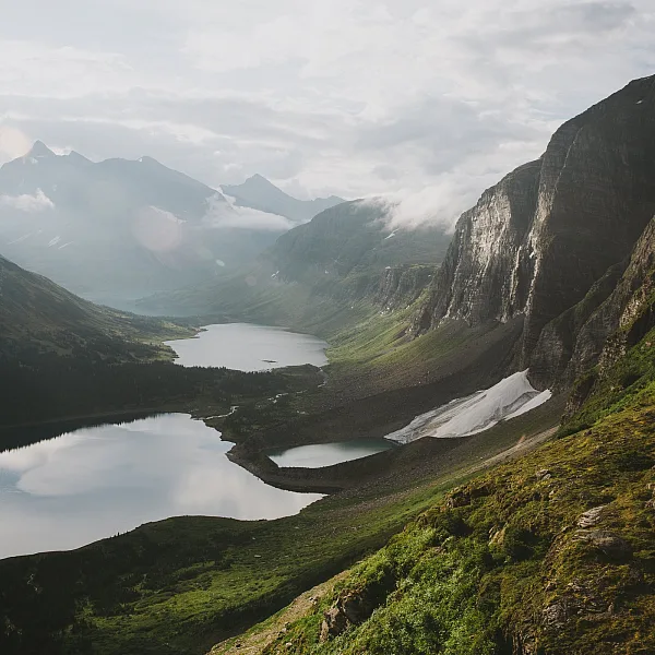 Hoch aufragende Berge und moosbedeckte Hochebenen überragen mehrere Bergseen.