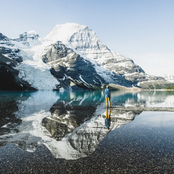 A person stands by a lake in Mount Robson Provincial Park