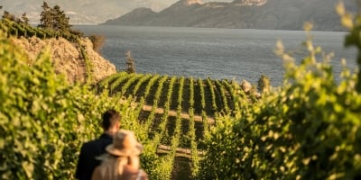 Two people at Evolve Cellars Vineyard with views of Okanagan Lake