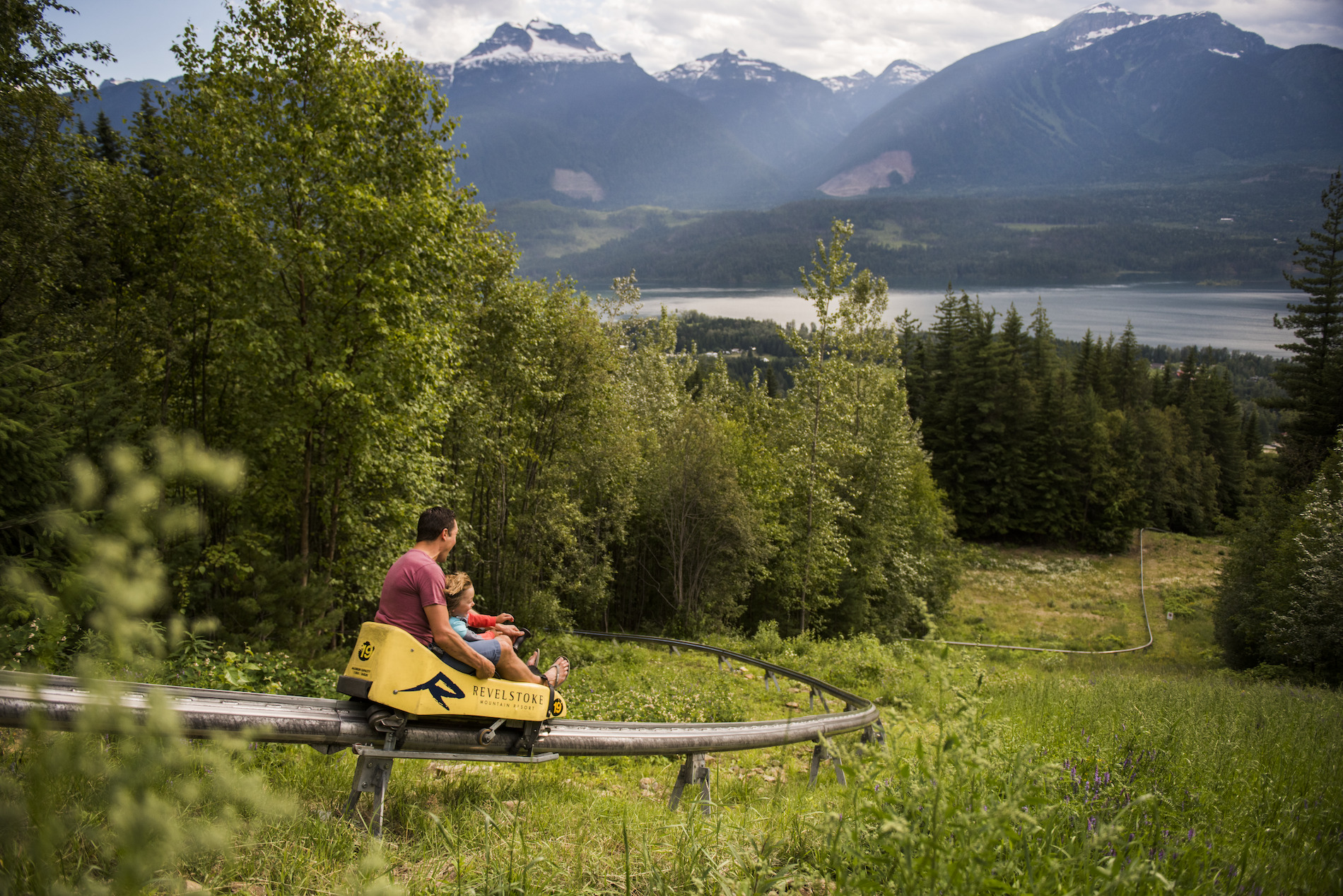 A parent and child enjoy The Pipe Mountain Coaster at Revelstoke Mountain Resort in Revelstoke, BC.
