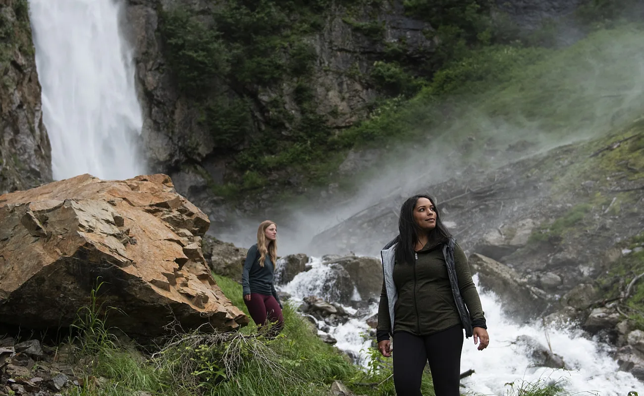 People hiking next to a river
