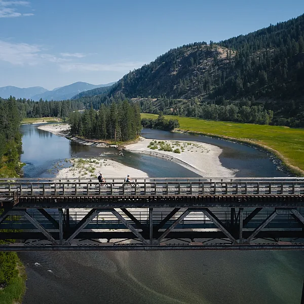 Paseando en bicicleta por un puente de caballetes en el Kettle Valley Trail en Christina Lake