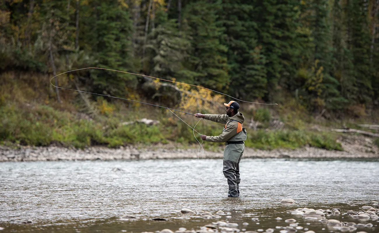 Una persona lanzando su caña para pescar con mosca en el Peace River.