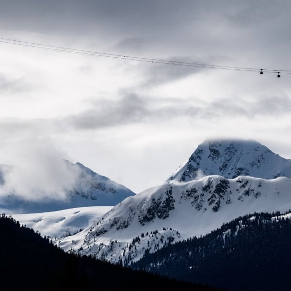 A view of the mountains with four Peak 2 Peak Gondolas crossing the valley in the distance.