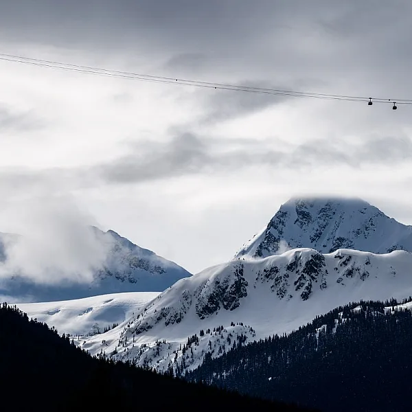 A view of the mountains with four Peak 2 Peak Gondolas crossing the valley in the distance.