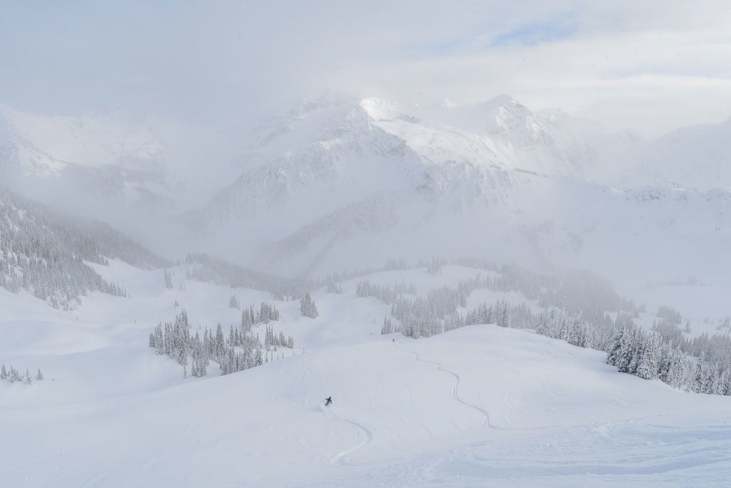People skiing down a mountain with Selkirk Tangiers Heli Skiing