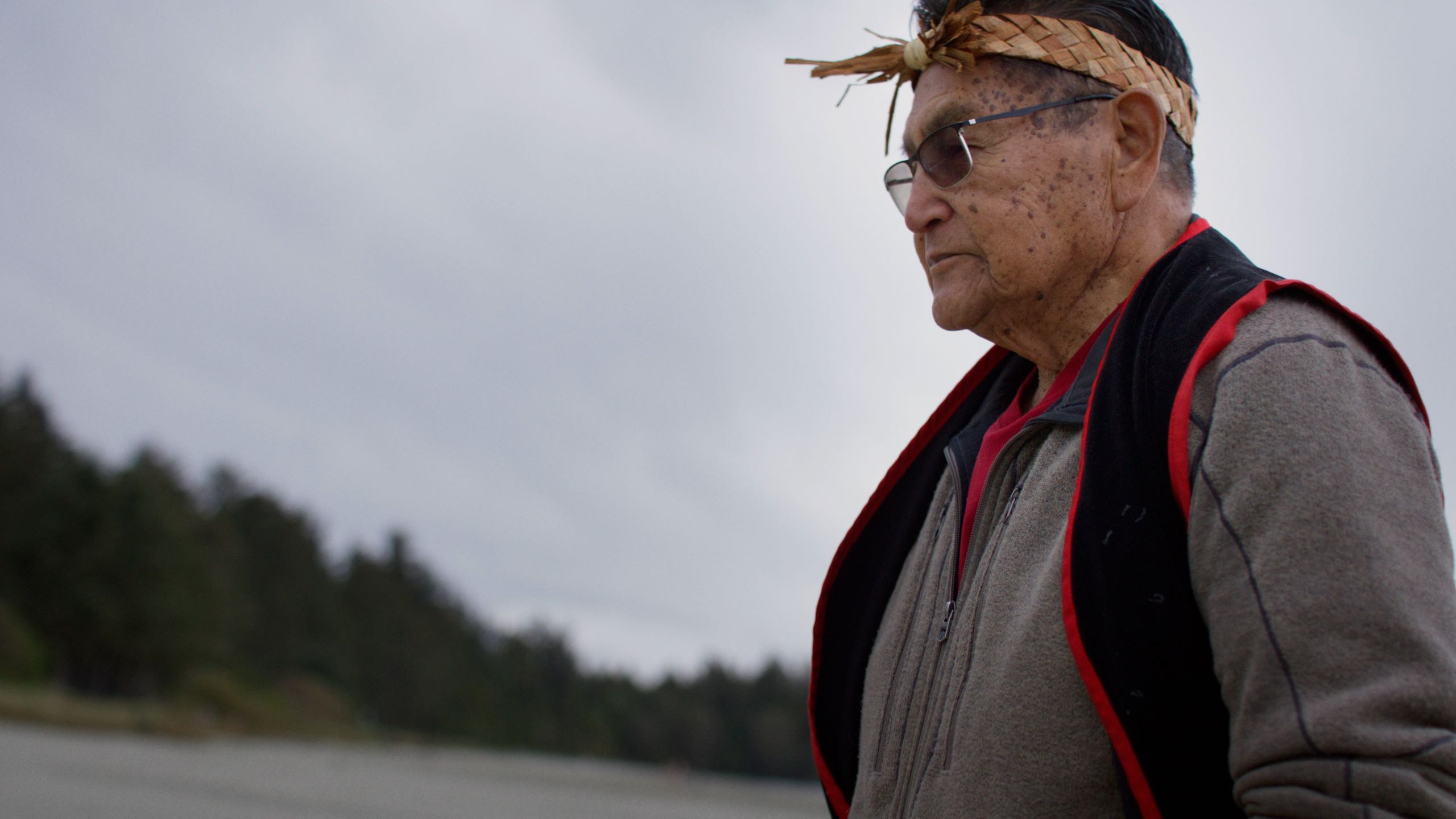 A still image of Moses Martin walking along a beach, taken from the Illahee: Whales video