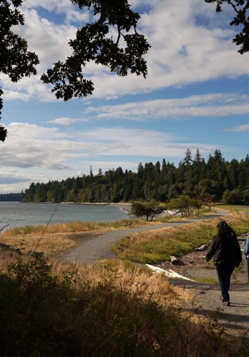 A family is exploring Pipers Lagoon Park on Vancouver Island. They are Bird Watching.