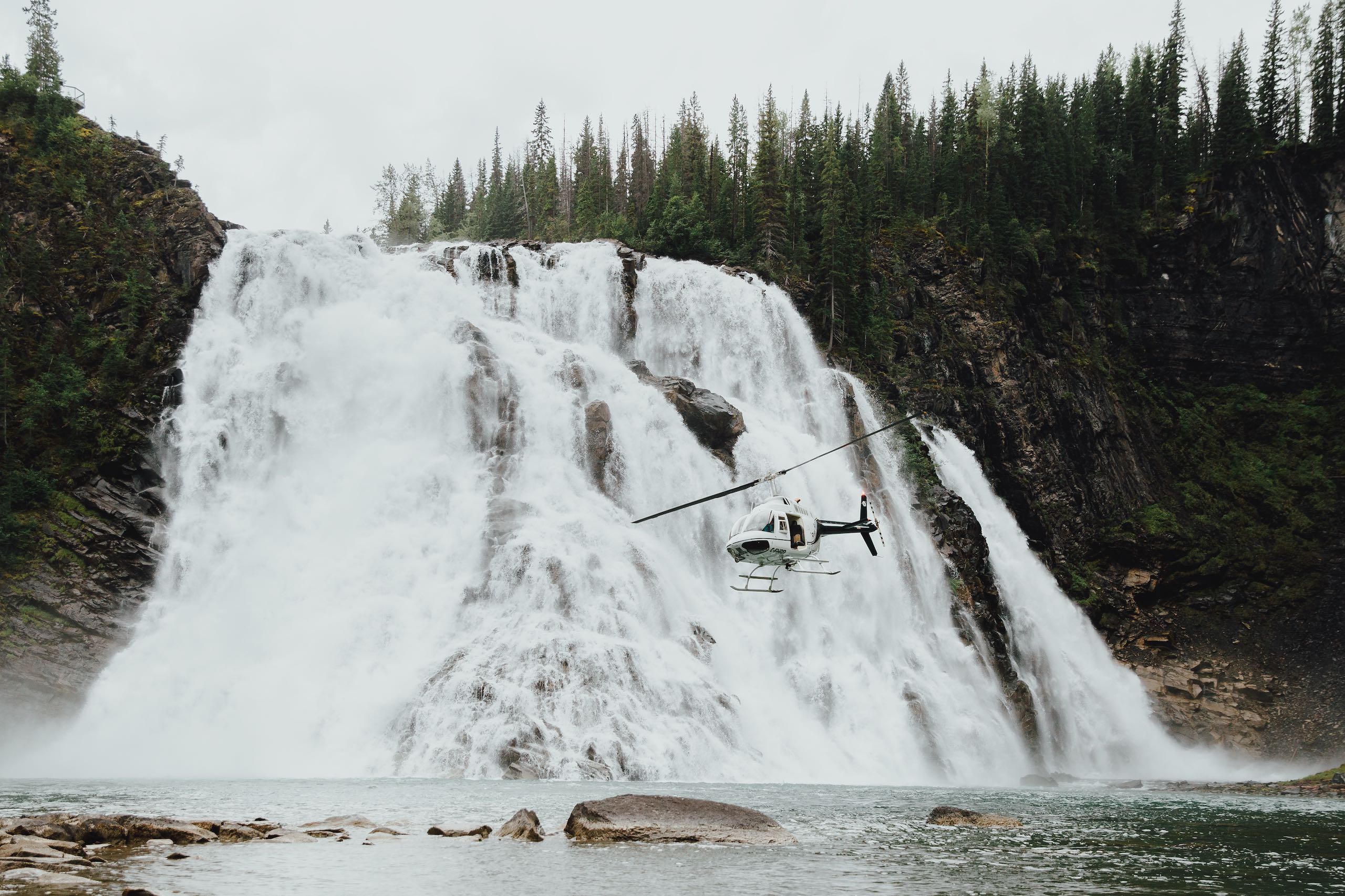 A helicopter flying near Kinuseo Falls, Monkman Provincial Park, Tumbler Ridge UNESCO Global Geopark