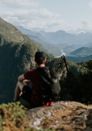 A man enjoying the view of the Fraser Canyon and surrounding mountains from the top of the Mount Lincoln Trail.