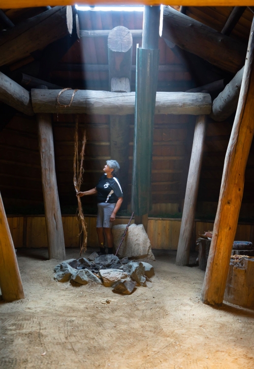 Indigenous interpreter in a historic pit house/lodge at Tuckkwiowhum Heritage Village